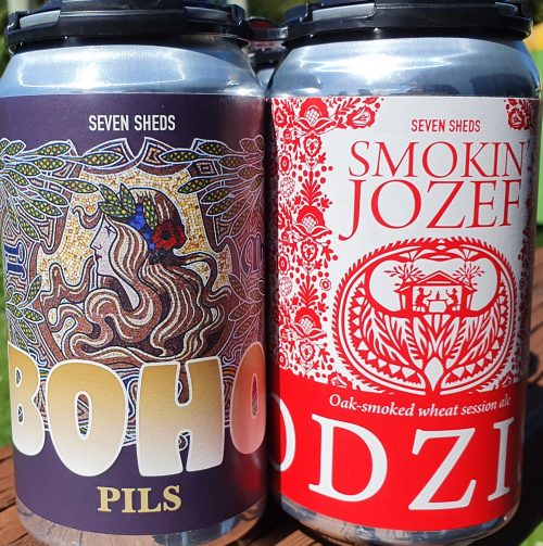 Two cans of beer, one is Boho Pils with a blue & gold label; and the other is Smokin Jozef with a red and white label